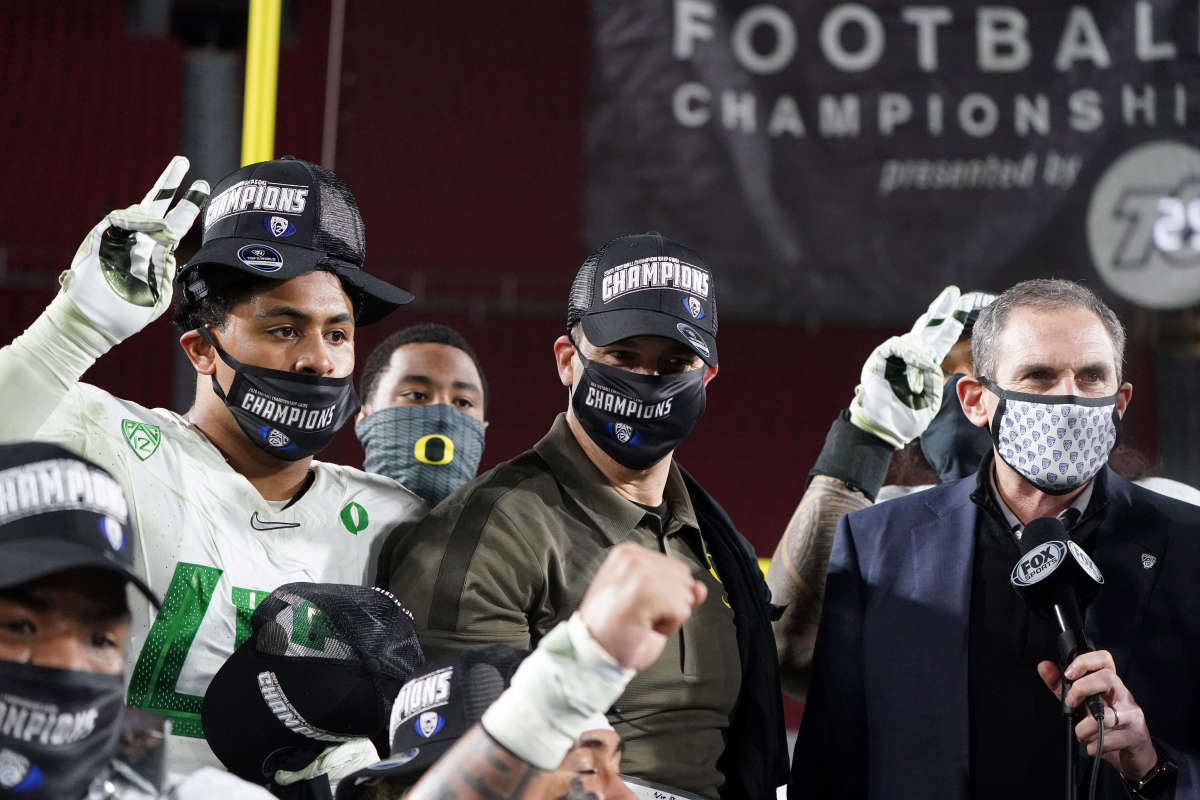 Mario Cristobal stands next to former Pac-12 commissioner Larry Scott after winning the 2020 conference title in Los Angeles.